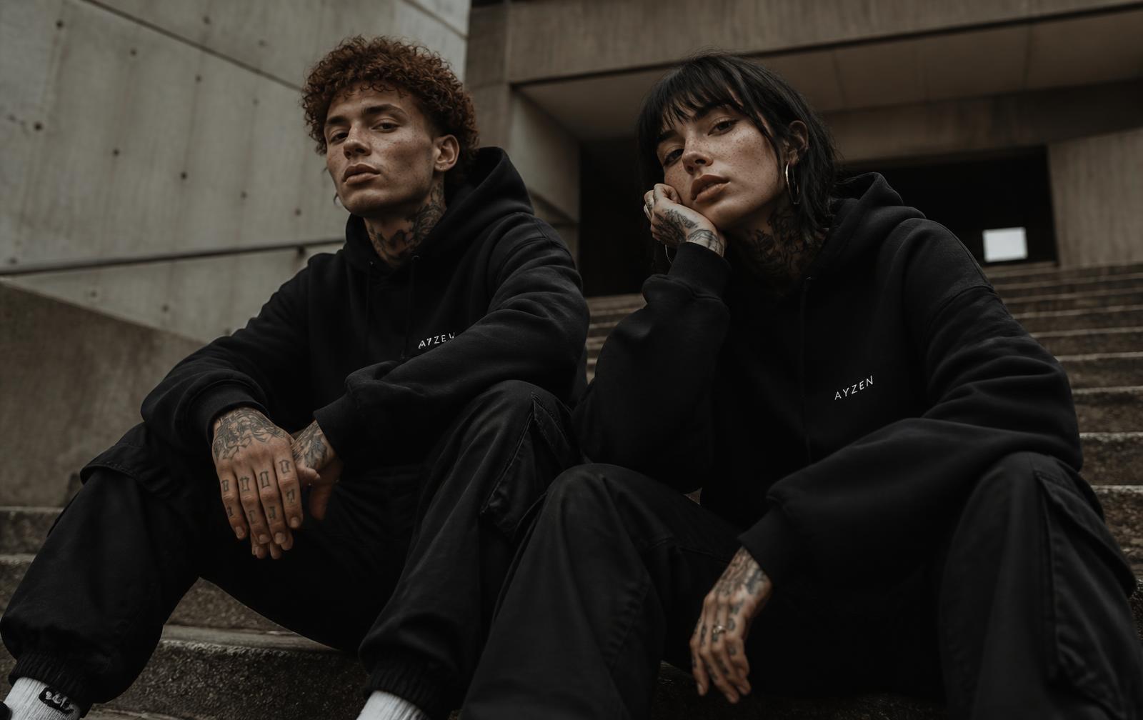 Zwei Models in Rimari Hoodies und Cargos auf Betonstufen
